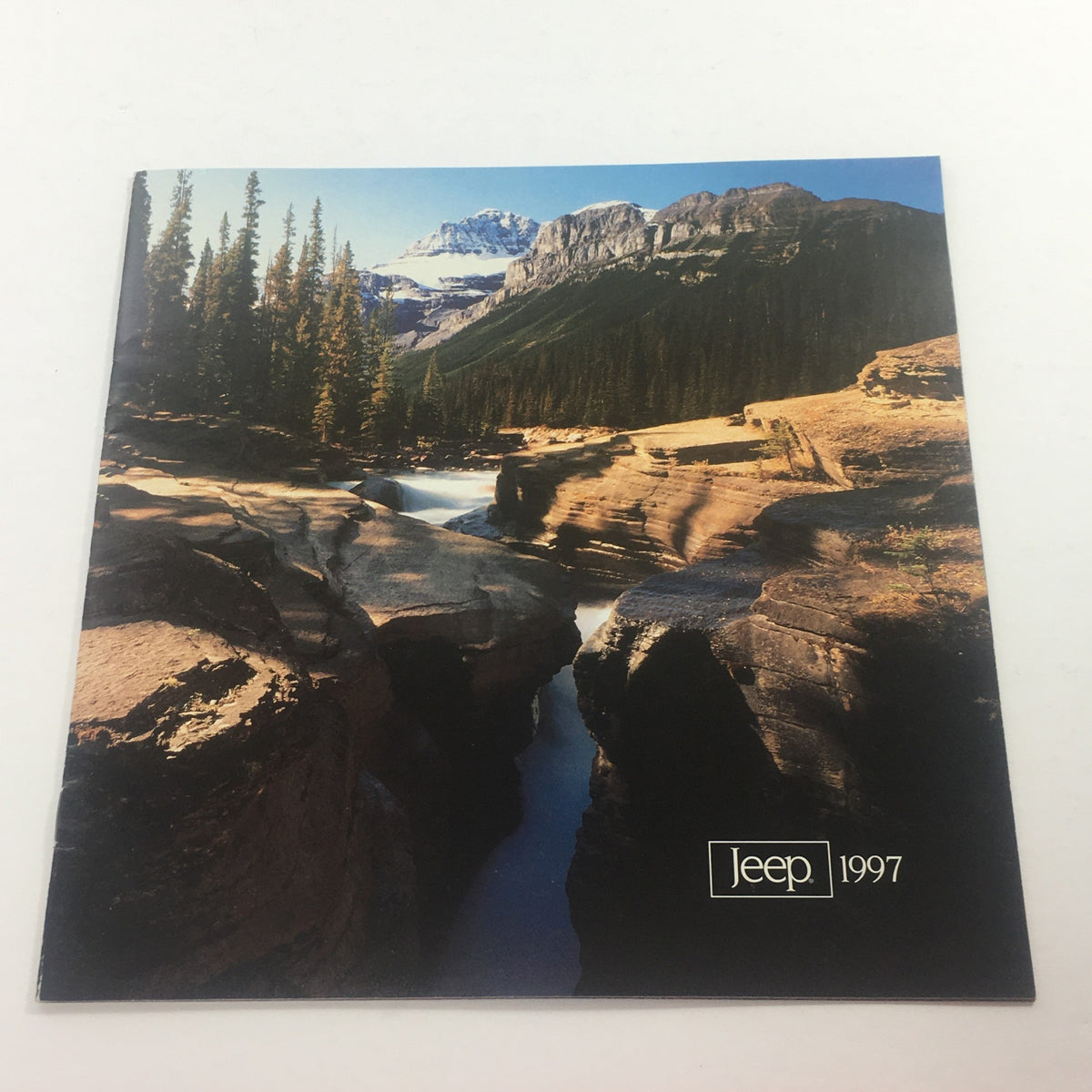 1997 Jeep 4-Wheel Drive Dealership Car Auto Brochure Catalog showcasing a scenic nature background with rocky terrain and a river, perfect for automotive enthusiasts.