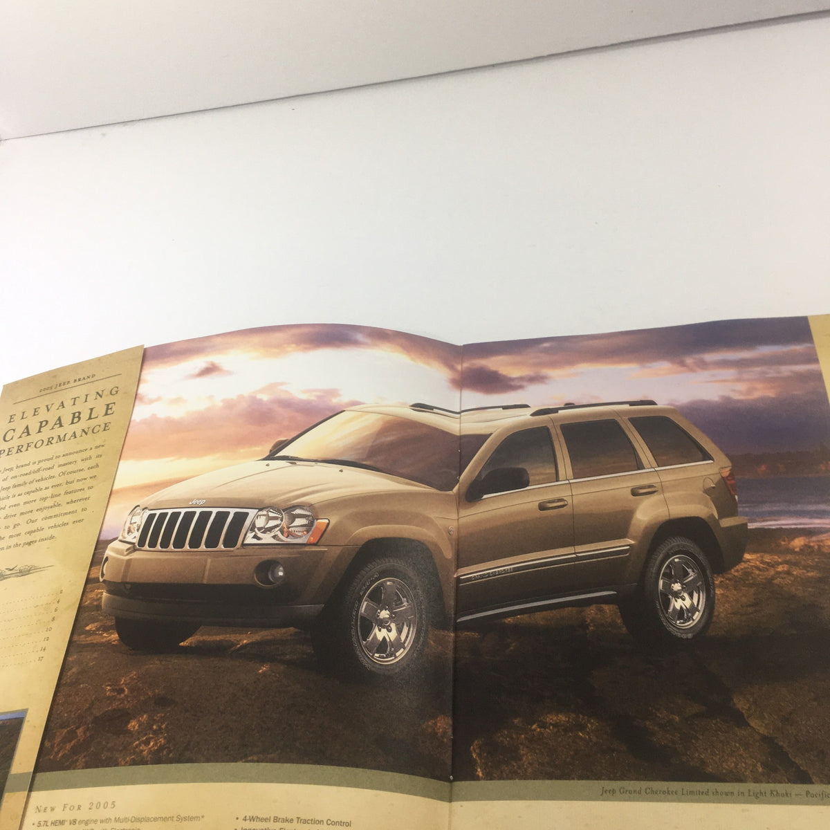 Inside view of the 2005 Jeep dealership brochure catalog showcasing the 2005 Jeep Grand Cherokee model, parked by the beach with detailed vehicle features.