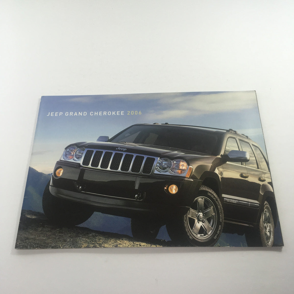 2006 Jeep Grand Cherokee Dealership Car Auto Brochure Catalog featuring a front view of the SUV with scenic mountains in the background, showcasing its design and features.