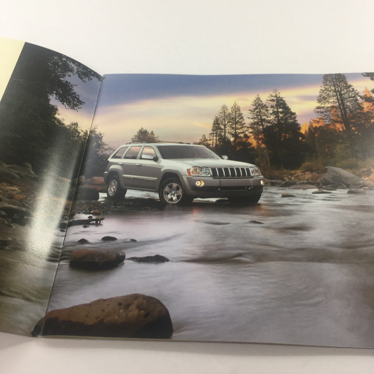 Inside page of the 2006 Jeep Grand Cherokee Dealership Car Auto Brochure Catalog showcasing the Jeep Grand Cherokee parked beside a river during sunset.