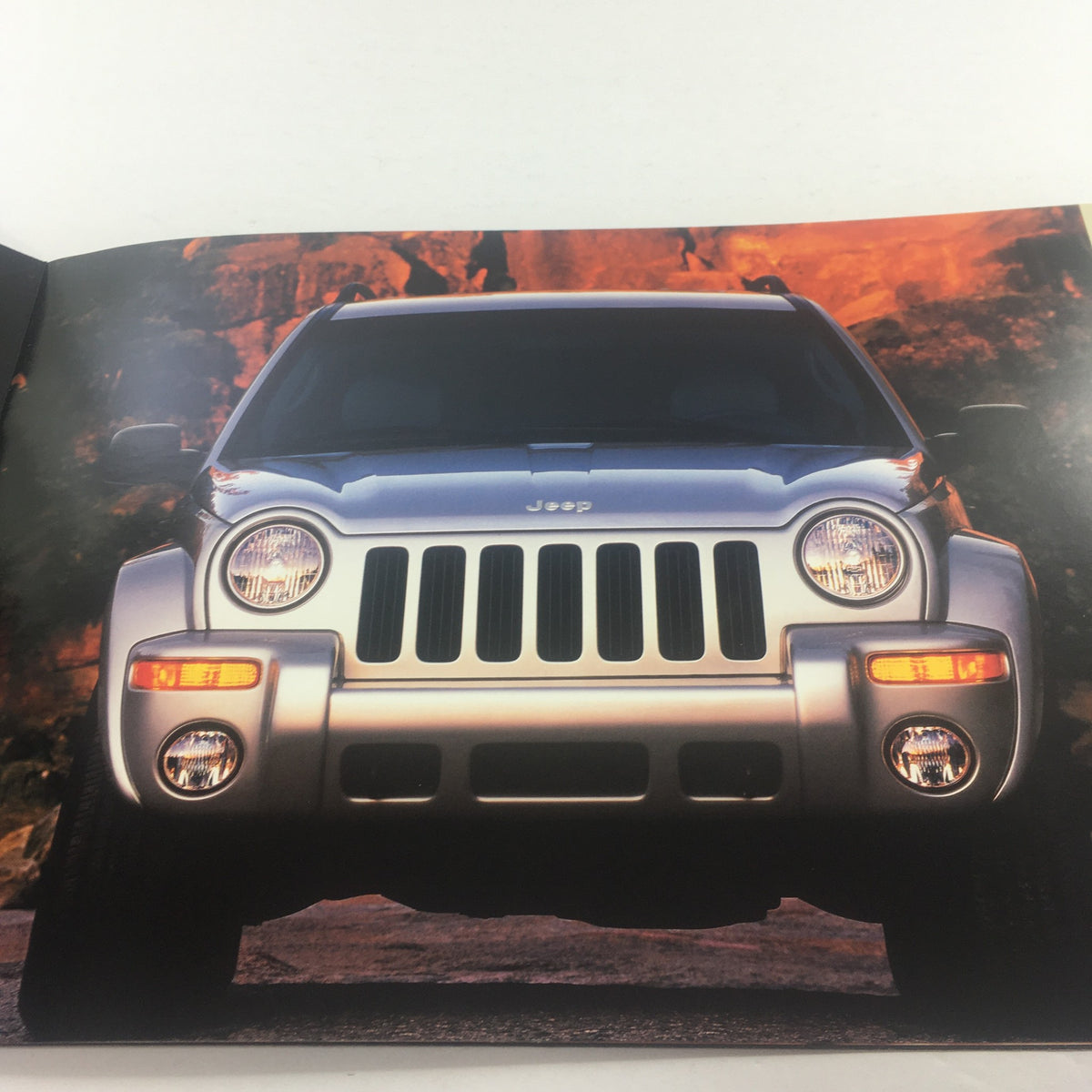 Front view of a 2002 Jeep Liberty showcasing its iconic grille and headlights, featured in the 2002 Jeep Liberty Dealership Car Auto Brochure Catalog.