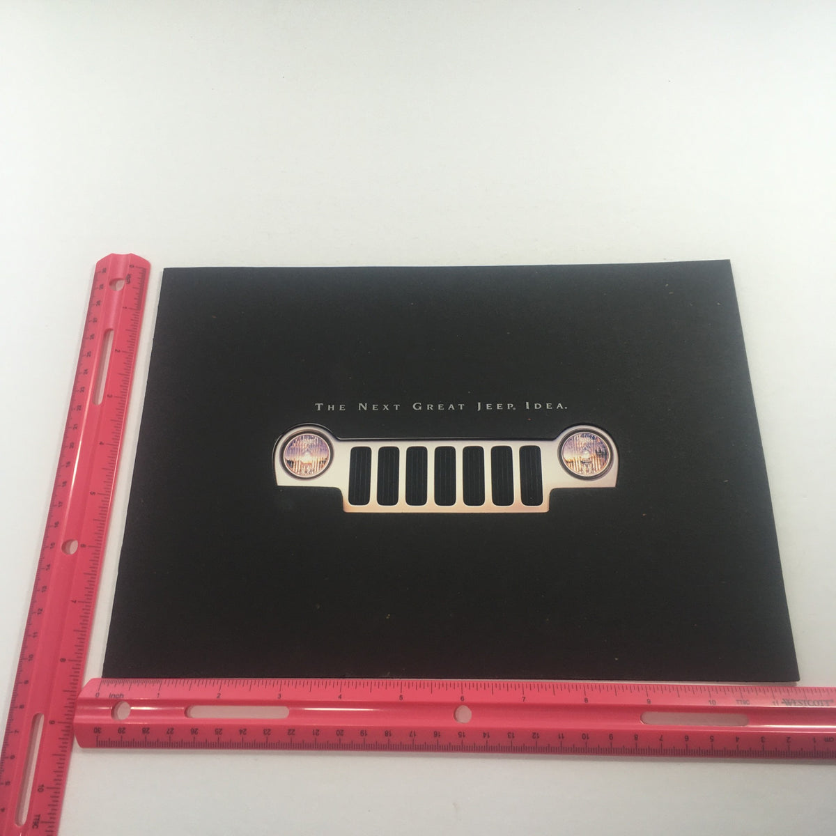 Illustration of the front grille of the Jeep Liberty, accompanied by a measuring ruler, featured in the 2002 Jeep Liberty Dealership Car Auto Brochure Catalog.