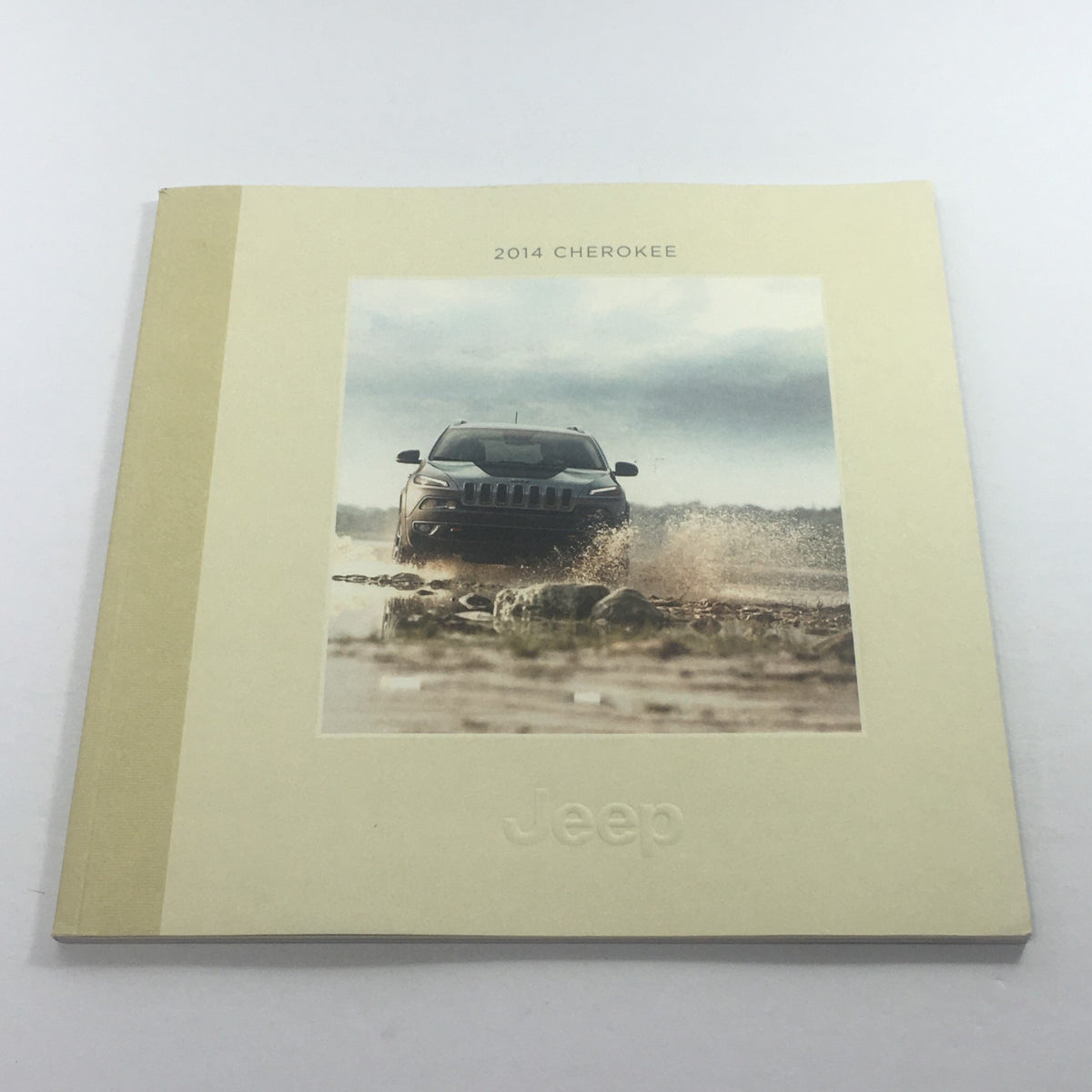 2014 Jeep Cherokee SUV Dealership Car Auto Brochure showcasing the front cover with a Jeep vehicle driving through water, highlighting its rugged design.