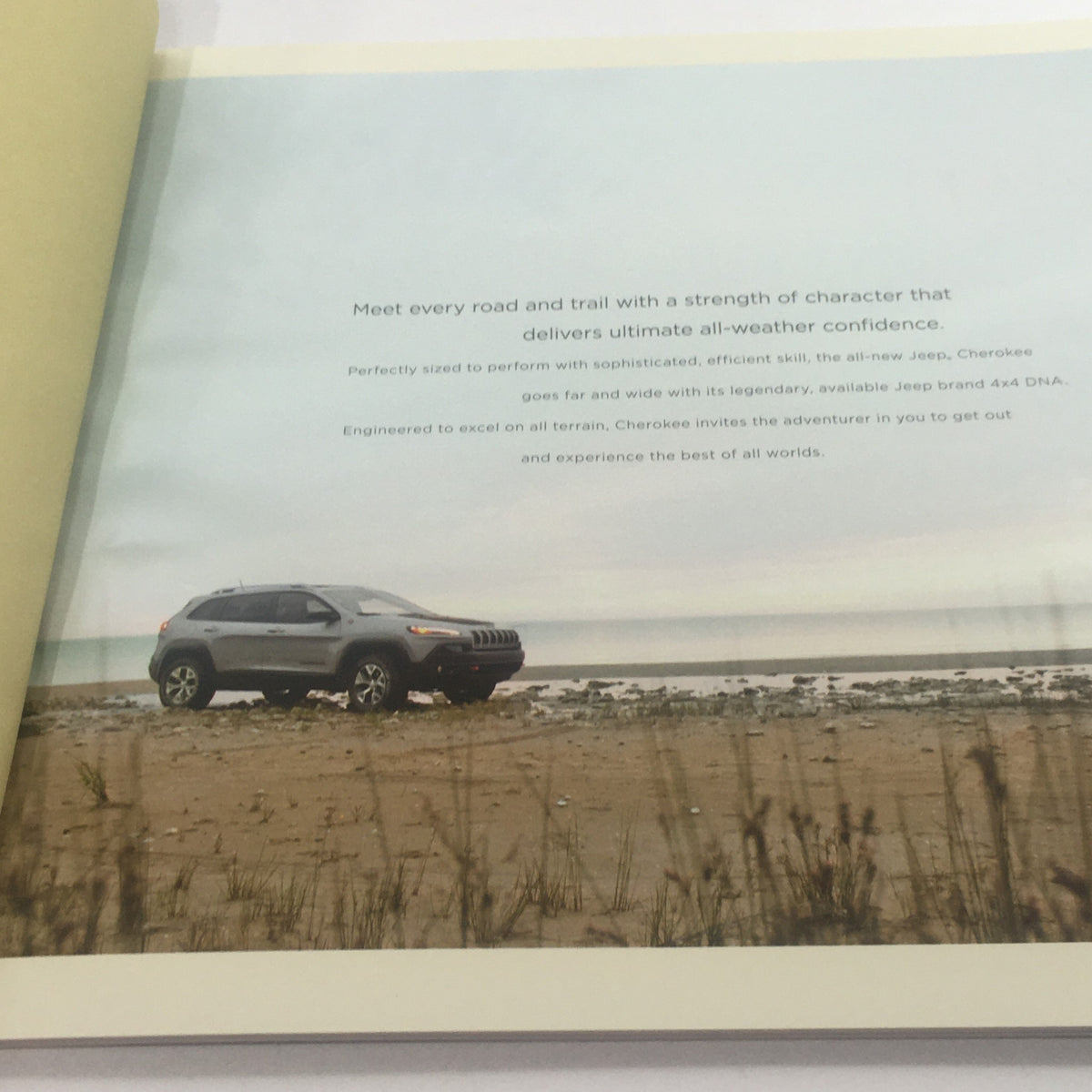 2014 Jeep Cherokee SUV Dealership Car Auto Brochure Catalog showcasing the vehicle on a beach, emphasizing its all-weather confidence and off-road capabilities.