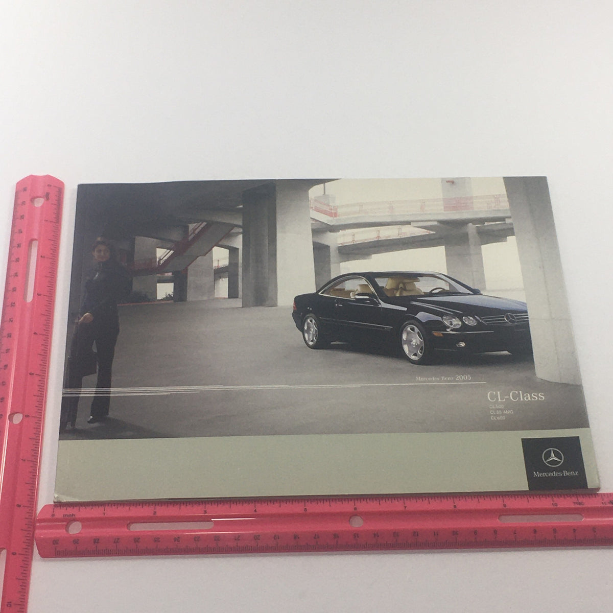 Cover image of the 2005 Mercedes-Benz CL-Class dealership car auto brochure catalog, displaying a stylish coupe parked in a modern architectural setting.