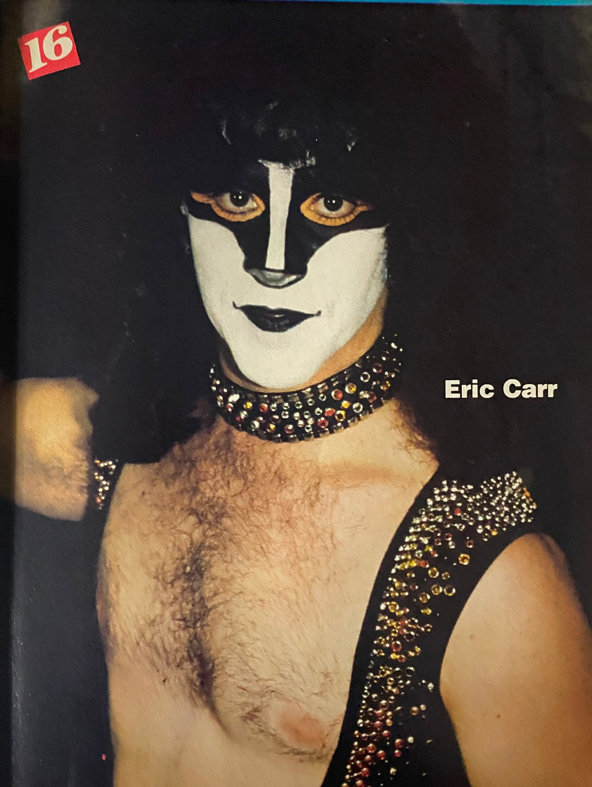 Photo of Eric Carr from 16 Magazine March 1981, dressed in stage makeup and attire, representing the glam rock era of the 1980s.