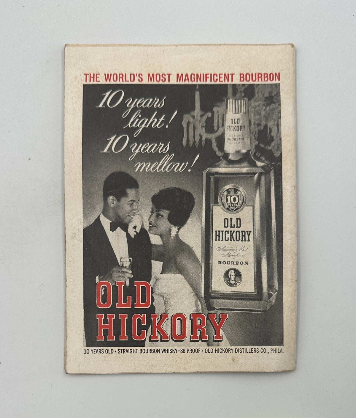 Vintage advertisement for Old Hickory Bourbon featuring a couple enjoying a toast. Text reads 'The World's Most Magnificent Bourbon', emphasizing '10 years light! 10 years mellow!' This ad was featured in Jet Magazine, April 6, 1961, with Adam Clayton Powell Jr. on the cover.