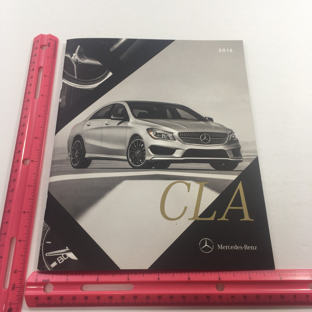 Close-up of the 2016 Mercedes-Benz CLA Dealership Car Auto Brochure cover showing the CLA model and a ruler for size reference.