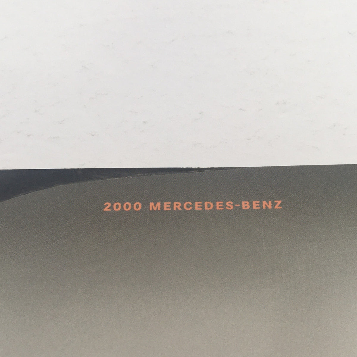 Top view of the 2000 Mercedes-Benz logo on the dealership car auto brochure catalog.