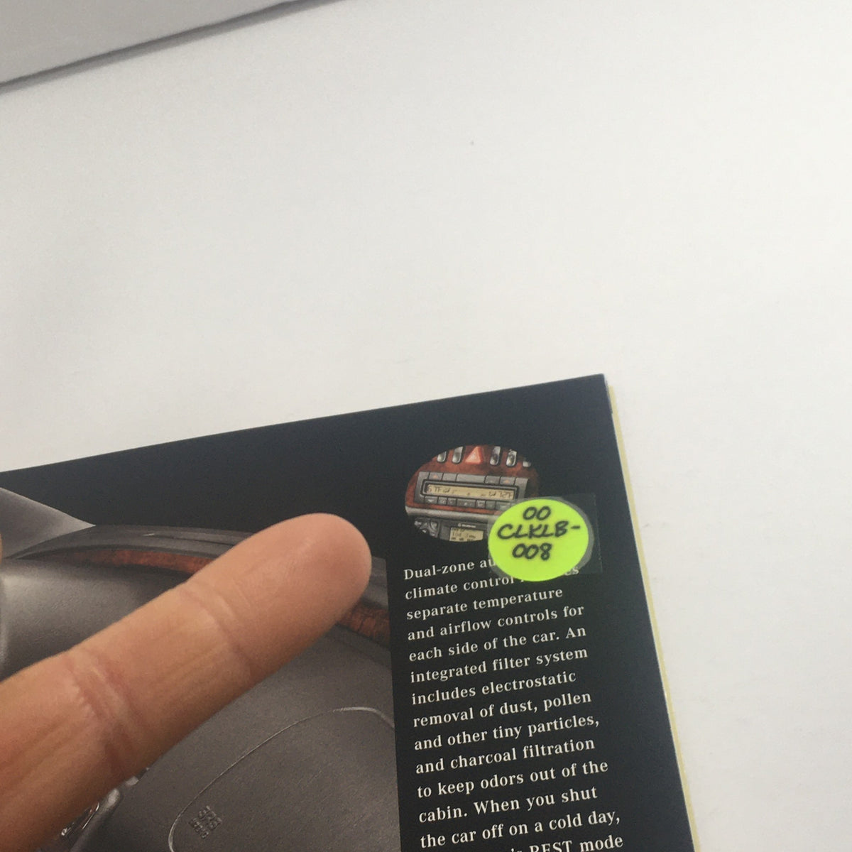 Page from the 2000 Mercedes-Benz CLK-Class Dealership Car Auto Brochure Catalog highlighting dual-zone climate control with a finger pointing to information.