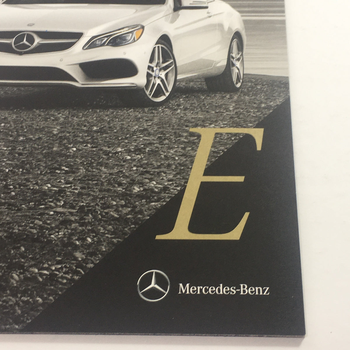 Close-up of the 2016 Mercedes-Benz E-Class Coupe/Cabriolet Dealership Car Auto Brochure Catalog showcasing a white luxury car with elegant design.