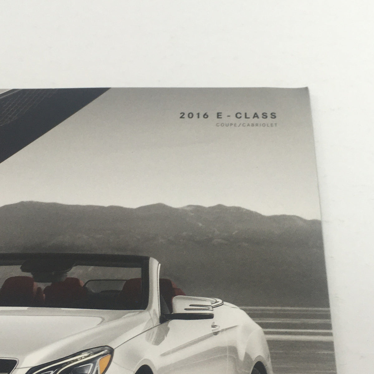Top view of the 2016 Mercedes-Benz E-Class Coupe/Cabriolet Dealership Car Auto Brochure Catalog highlighting the convertible's stylish features and scenic background.