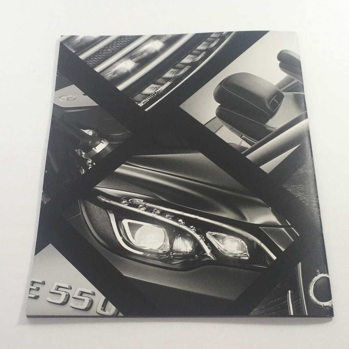 Close-up of a black and white artistic depiction of the headlight and grill of a 2016 Mercedes-Benz E-Class Coupe, as featured in the dealership car auto brochure catalog.