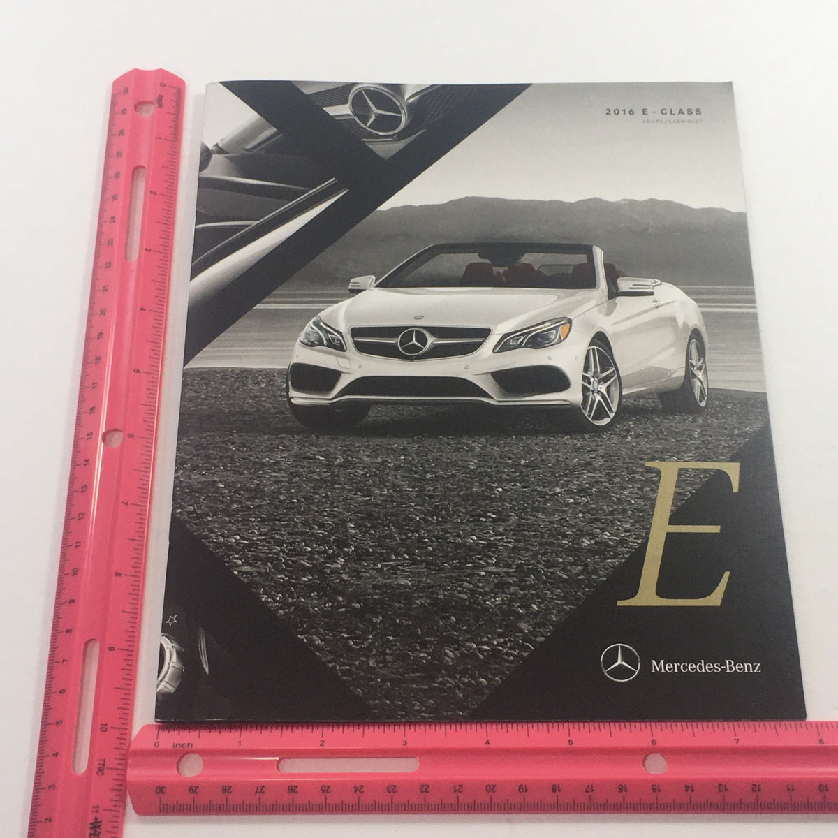 Front view of a white 2016 Mercedes-Benz E-Class Cabriolet with a scenic background, part of the dealership car auto brochure catalog.