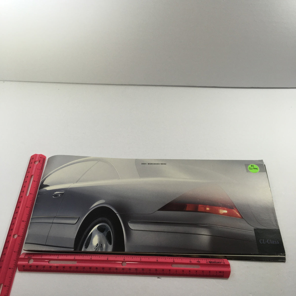 2001 Mercedes-Benz CL-Class Dealership Car Auto Brochure Catalog featuring the rear view of the luxury vehicle, showing its sleek design and distinctive taillights, with a ruler for size reference.
