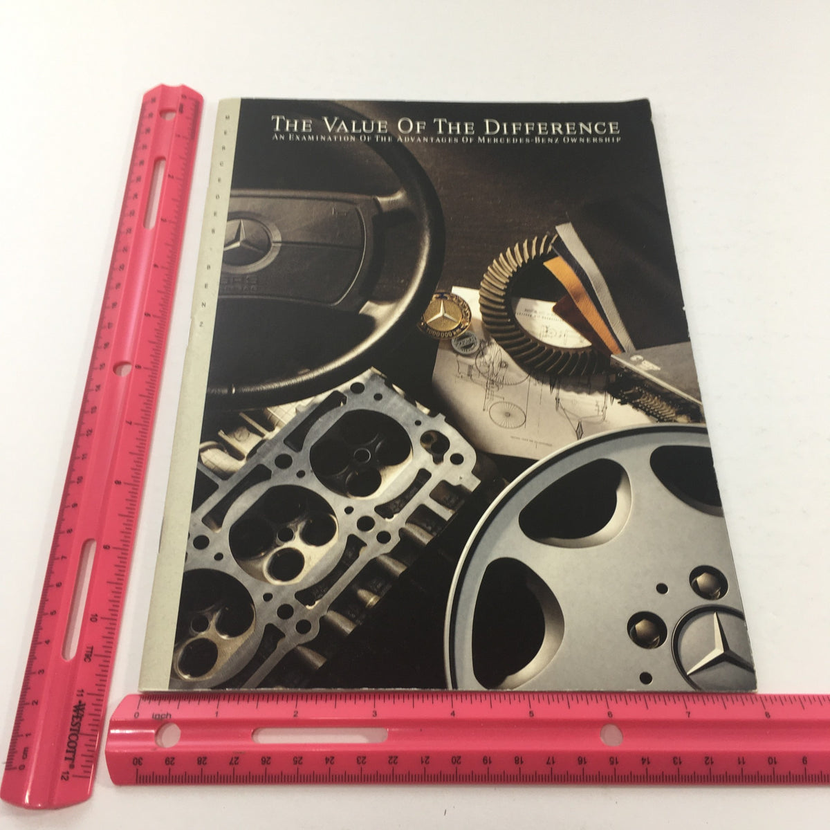 Front of the 1992 Mercedes-Benz Value of Difference Dealership Car Auto Brochure Catalog, highlighting automotive components with a ruler for size reference.
