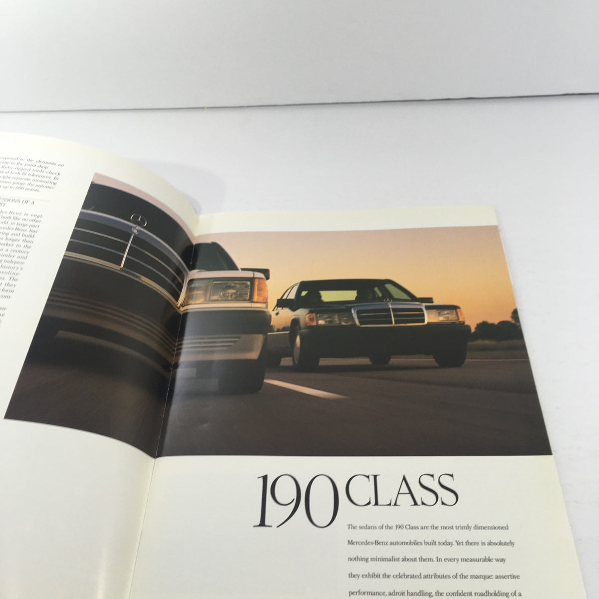 1989 Mercedes-Benz 190-Class 190E 2.6 Sedan Dealership Car Auto Brochure Catalog featuring two Mercedes-Benz vehicles on a road, showcasing the elegant design of the 190 Class.