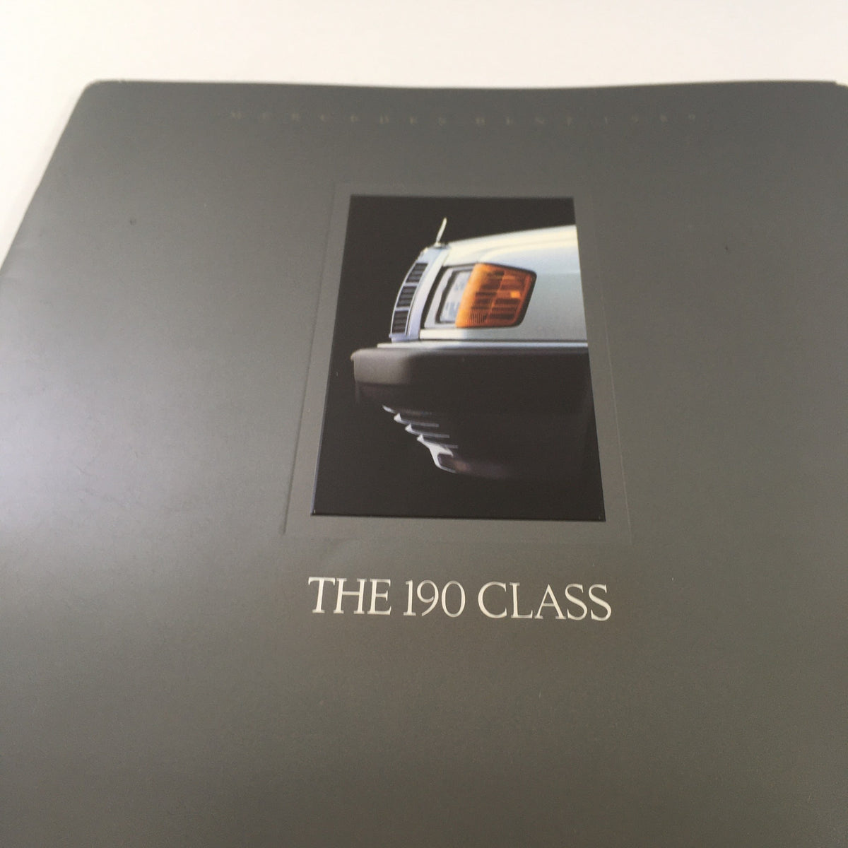 Detailed view of the 1989 Mercedes-Benz 190-Class Sedan Dealership Car Auto Brochure Catalog cover showcasing the title 'THE 190 CLASS' with a focus on the vehicle's grille and headlights.