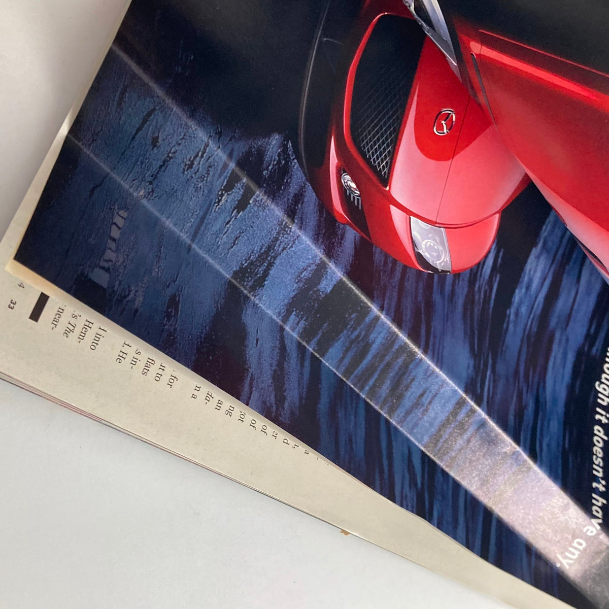 Inside page of Sports Illustrated Magazine Winter 2004 showing a vibrant image of a red car, emphasizing advertisements alongside swimsuit photography.