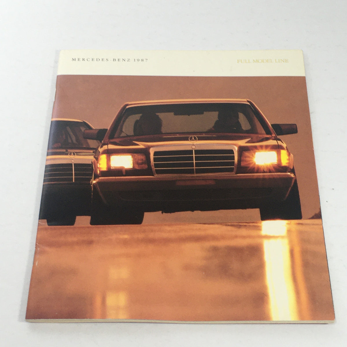 1987 Mercedes-Benz Full Model Line Dealership Car Auto Brochure Catalog cover featuring two Mercedes-Benz cars driving towards the camera at sunset.