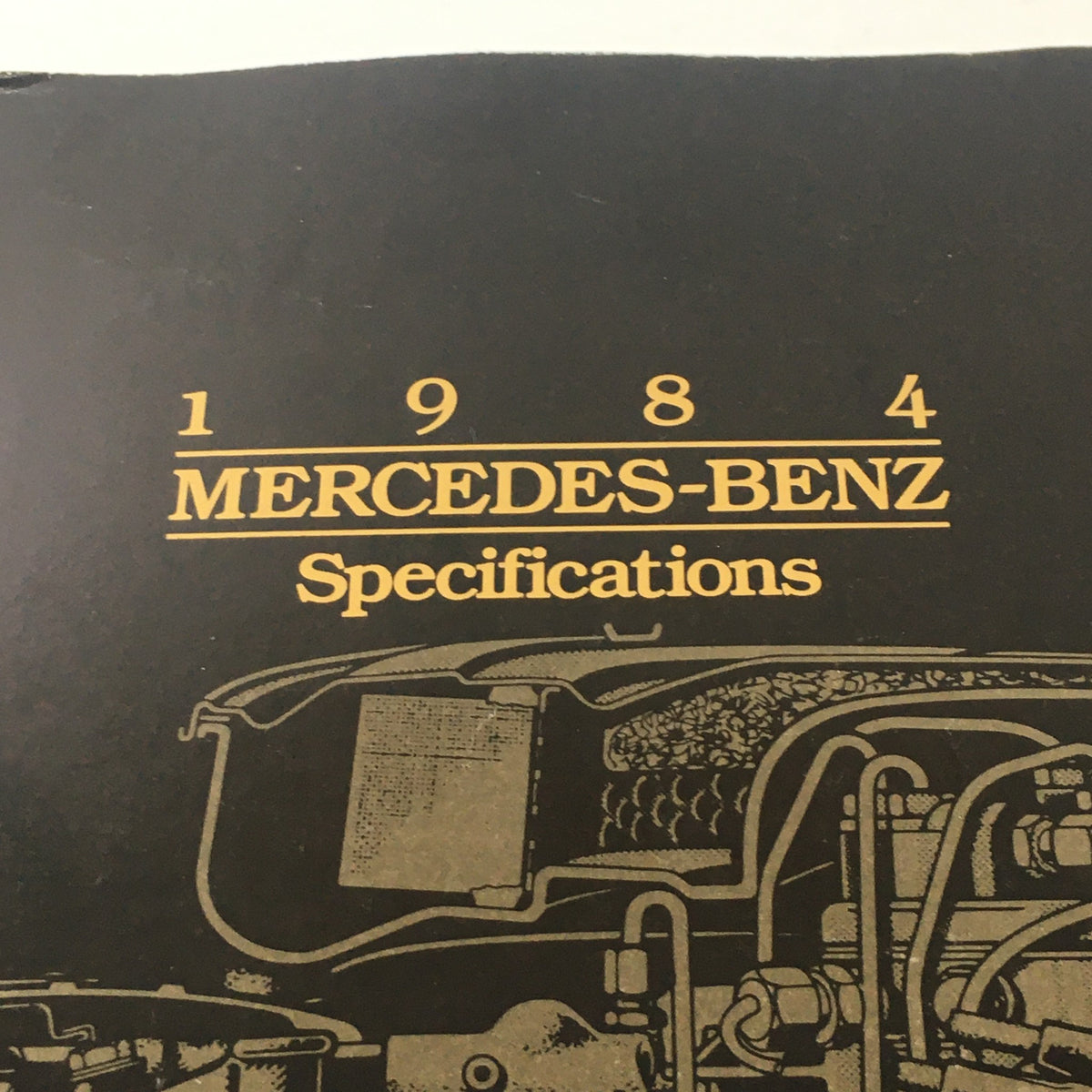 Close-up of the title section from the 1984 Mercedes-Benz Specifications Features Dealership Car Auto Brochure Catalog highlighting brand and specifications.