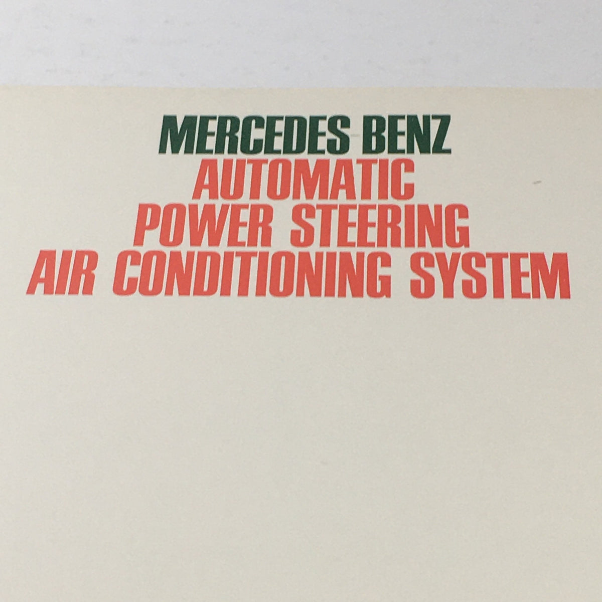 Close-up of the 1980s Mercedes-Benz AT/Power Steering Dealership Car Auto Brochure Catalog title, featuring bold text in green and red.
