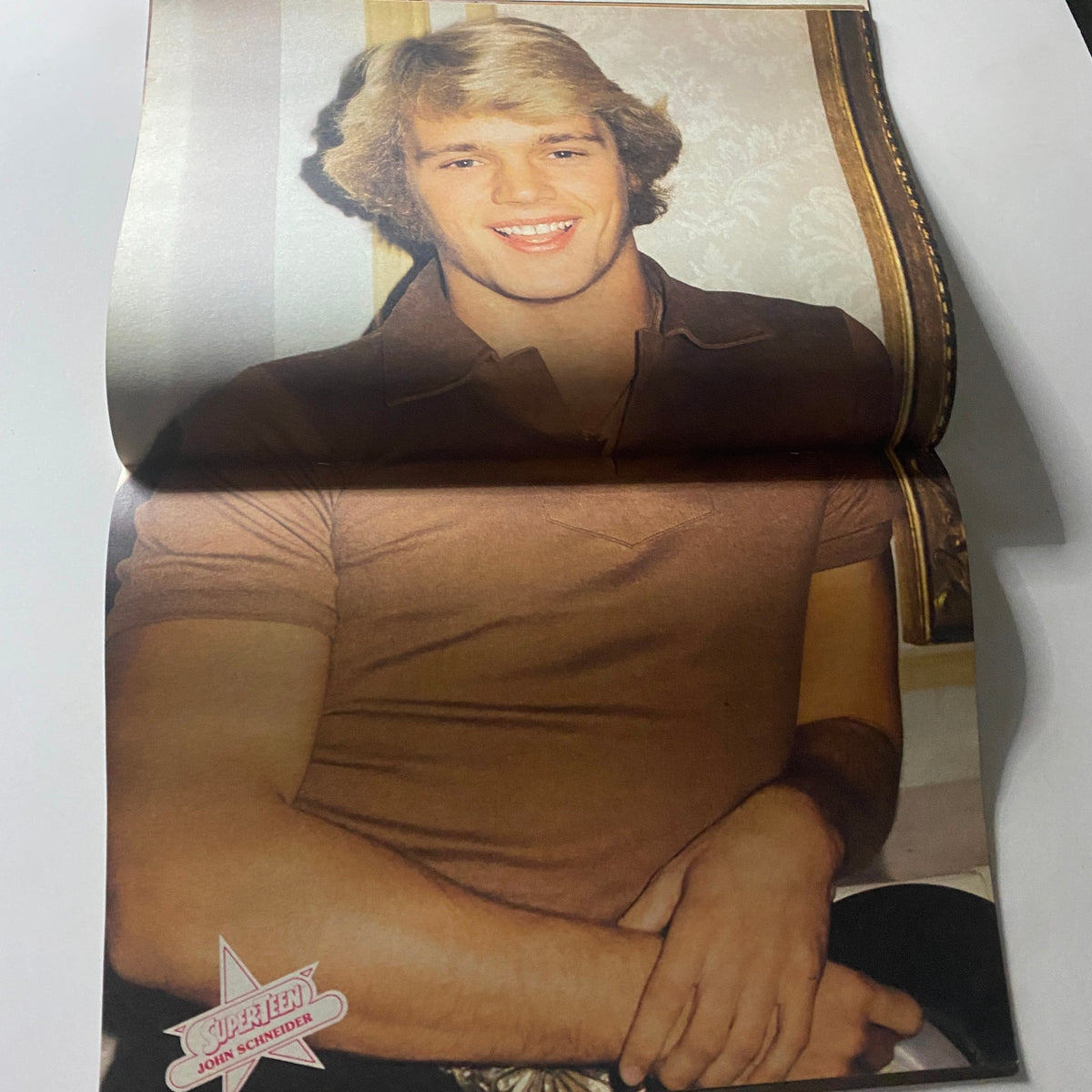Inside fold-out image of John Schneider in SuperTeen Pinup Book No. 2, smiling confidently, capturing the charm of 1980s heartthrobs.