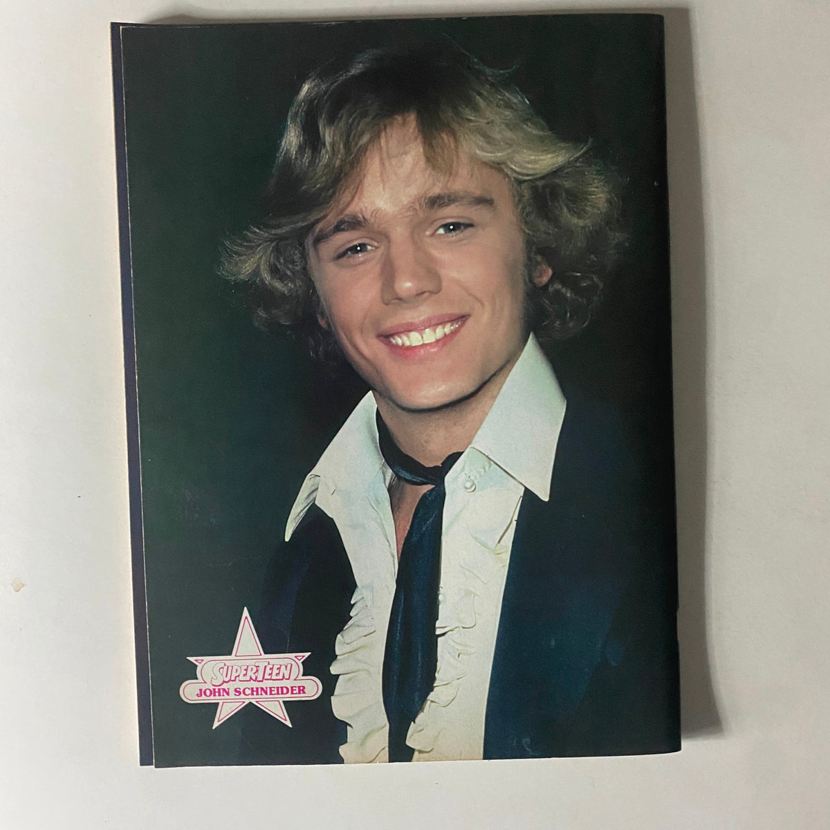 Portrait of John Schneider featured in SuperTeen Magazine August 1981 with a signature.