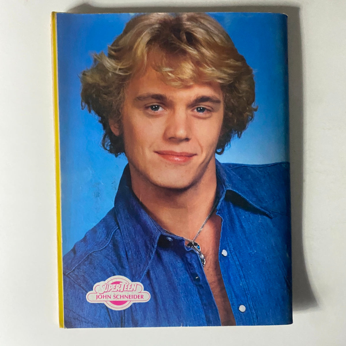 Image of actor John Schneider featured in SuperTeen Magazine August 1981, presenting a charming smile and stylish denim outfit.