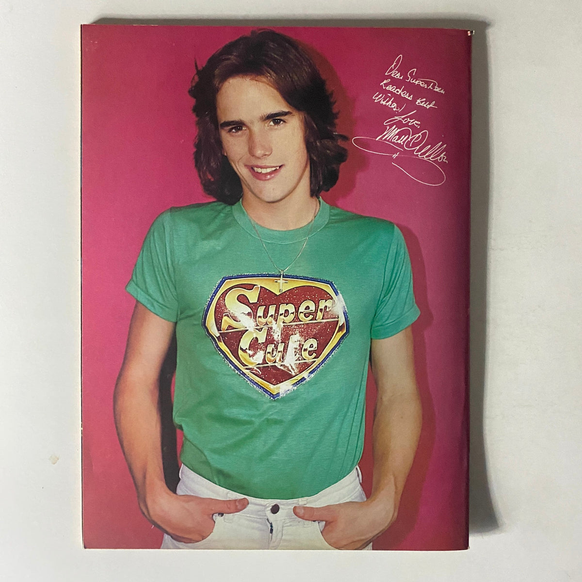 Portrait of a young male model wearing a green Super Cute t-shirt with a stylish haircut, featured in SuperTeen Magazine January 1981.