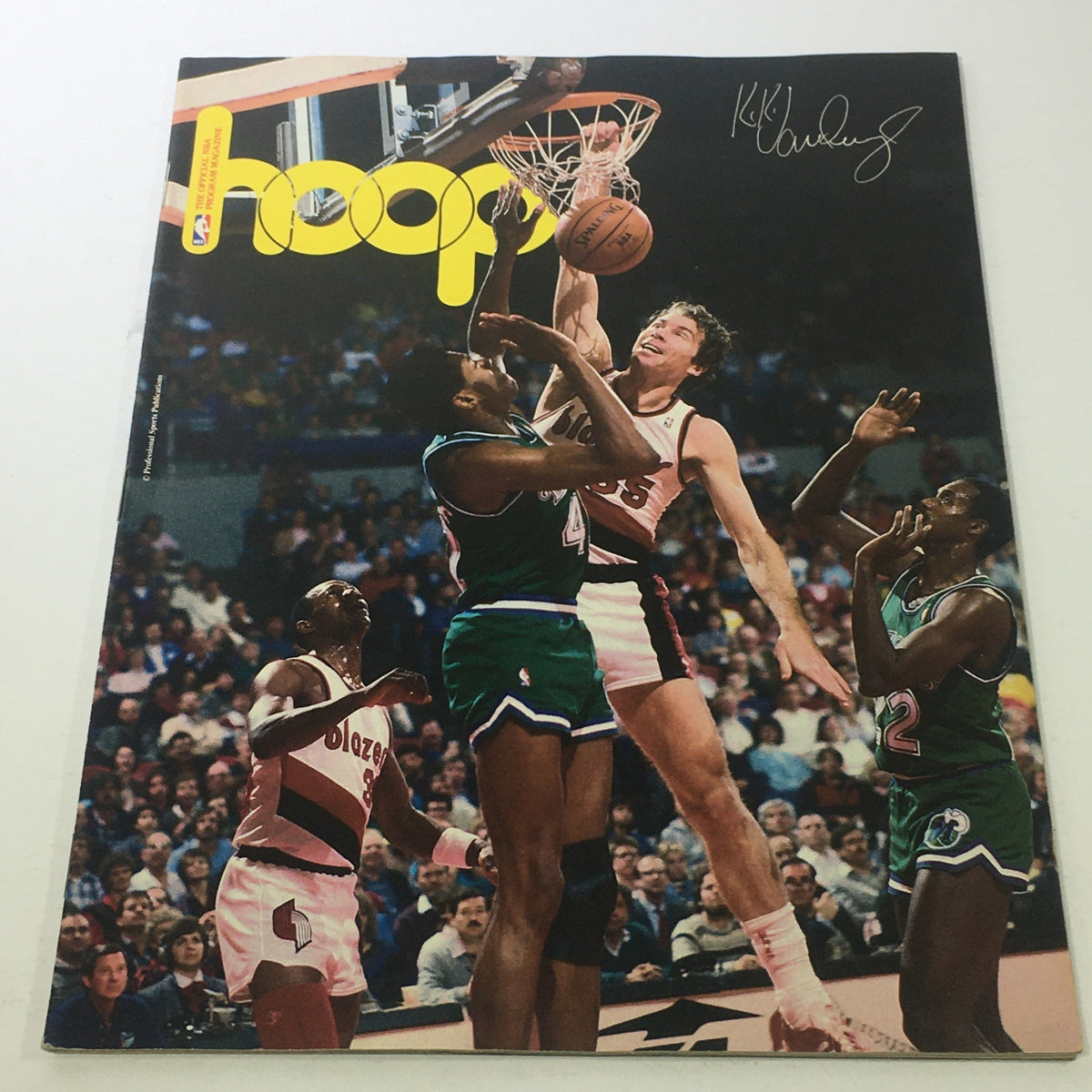 Hoop NBA Magazine from the 1980s featuring Kiki VanDeWeghe's signature, showcasing a dynamic basketball scene with multiple players in action during a game.