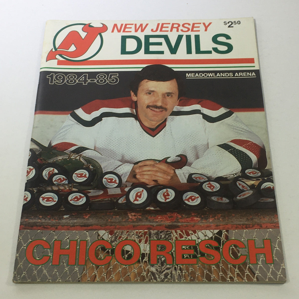 Vintage New Jersey Devils Magazine 1984-1985 featuring Chico Resch at Meadowlands Arena, showcasing a hockey theme with pucks and the iconic Devils logo.