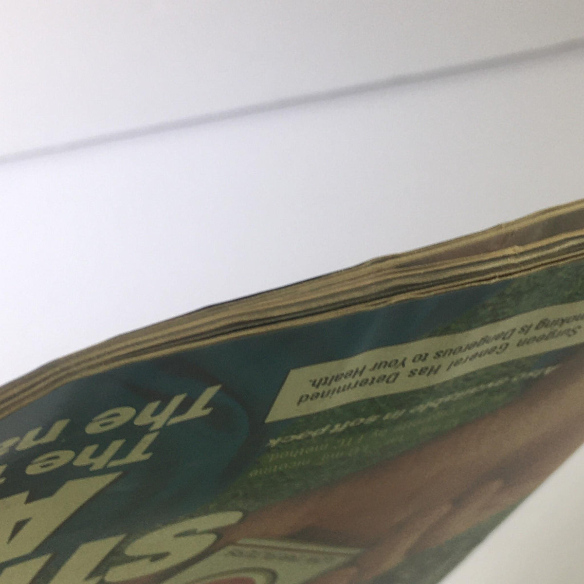 Close-up view of the edge of the Sports Illustrated magazine from March 5, 1984, highlighting its vintage feel with minor wear and tear, part of the description indicating 'No label'.
