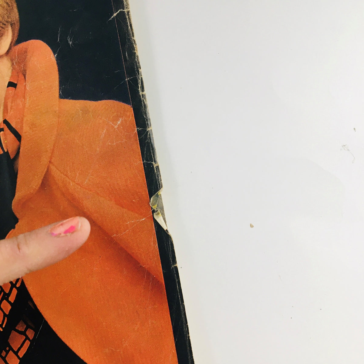 Close-up of the McCall's Magazine March 1966 cover highlighting a woman's orange coat, showcasing minor wear and tear.