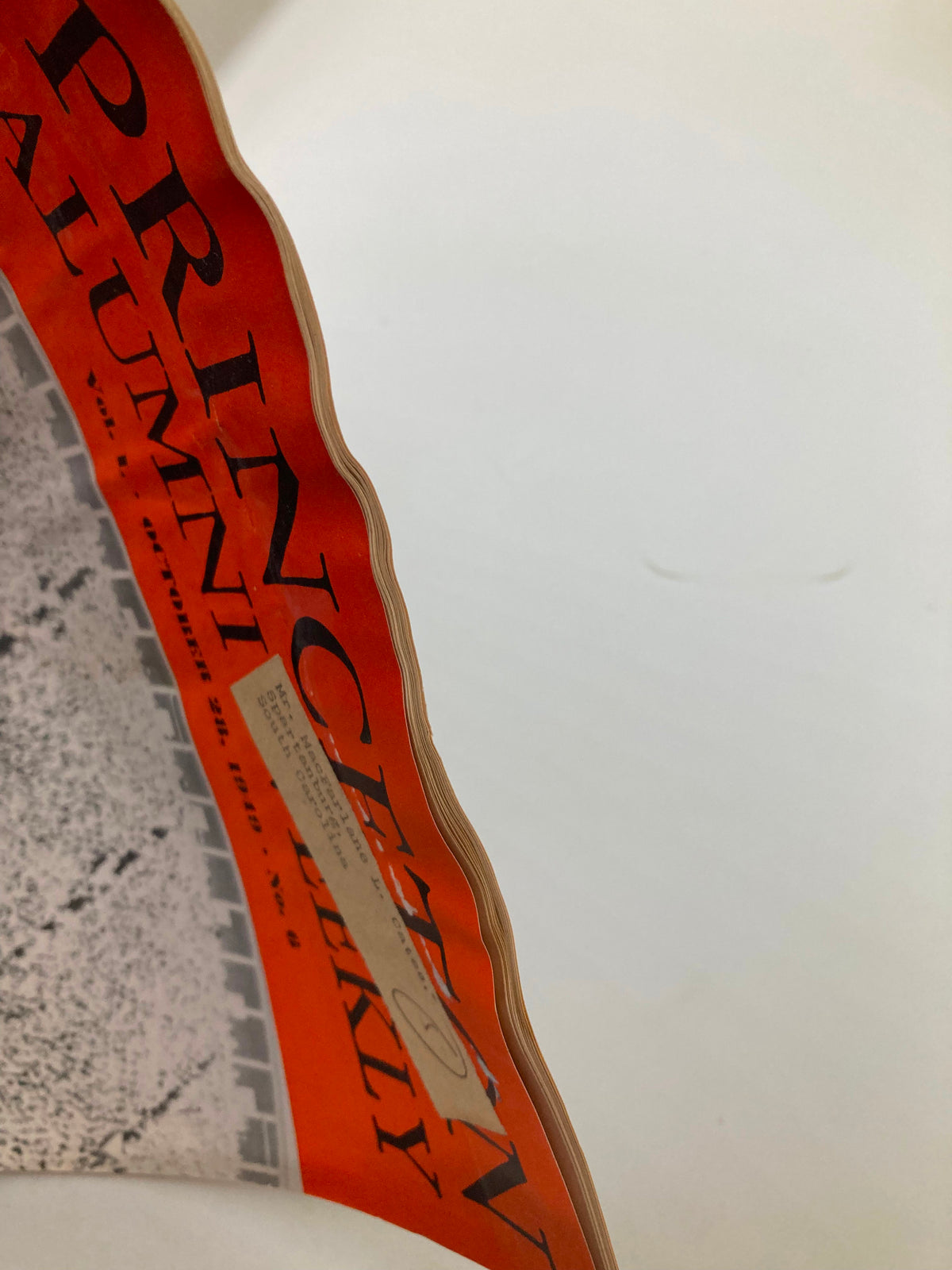 Side view of the VTG Princeton Alumni Weekly magazine from October 28, 1949, showcasing vintage wear along the edges and a label on the cover, reflecting the magazine's historical significance.
