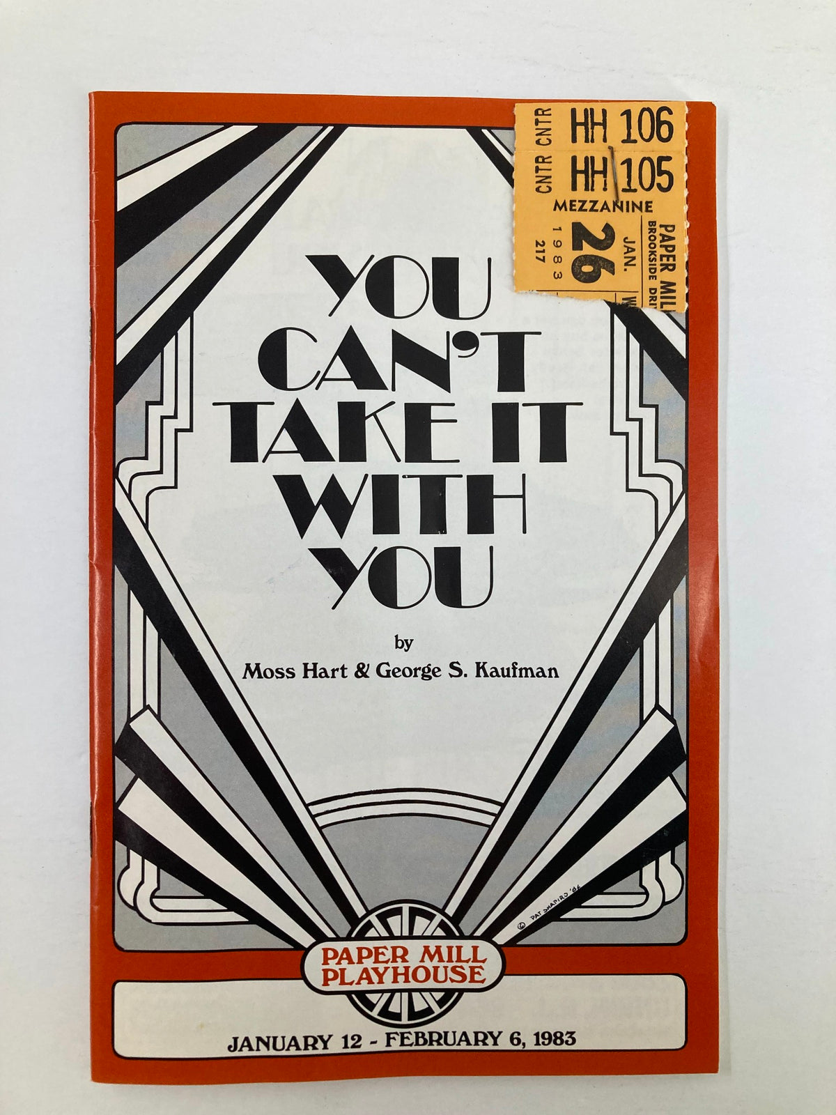 1983 program for 'You Can't Take It With You' by Moss Hart, featuring Art Deco design elements, with a ticket stapled to the front. This program is from Paper Mill Playhouse, showcasing performances from January 12 to February 6, 1983.