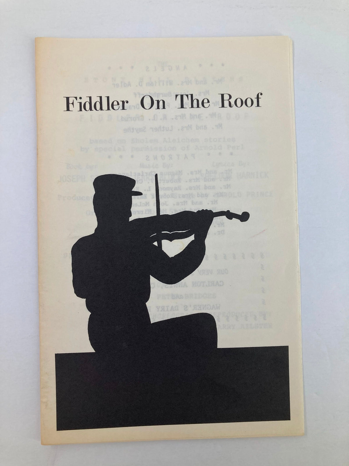 Cover of the 1984 program for 'Fiddler on the Roof' by Joann Churchill featuring a silhouette of a fiddler.