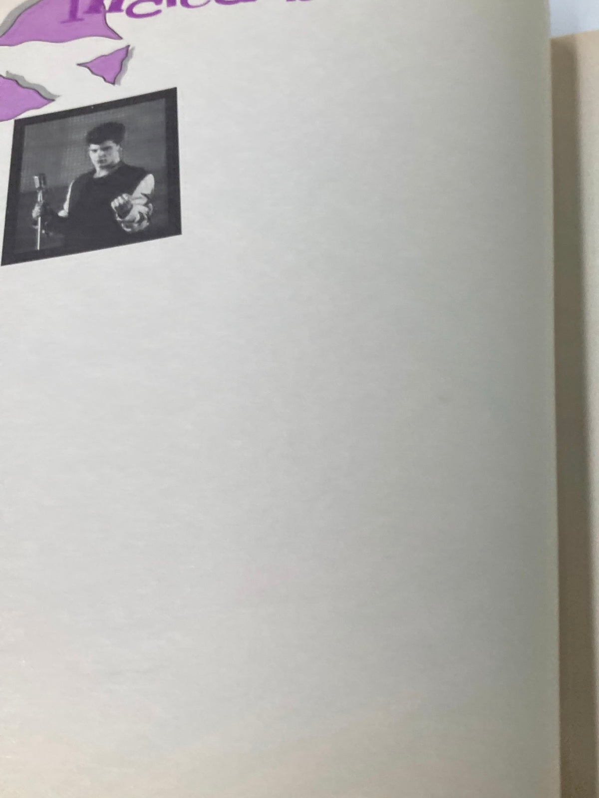 Image from the 1989 Official New Kids on The Block Bonus Scrapbook displaying an empty page with a small black-and-white photo of a male performer holding a microphone.