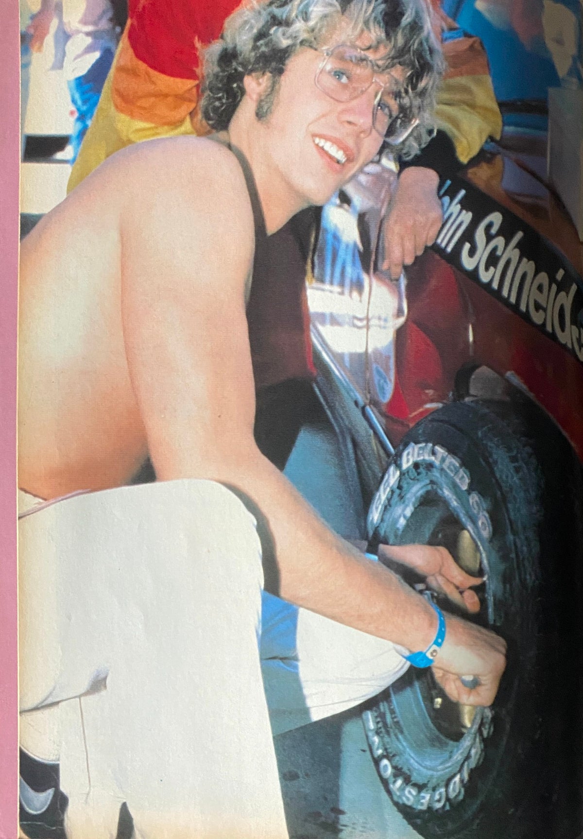 John Schneider featured in a photo from Tiger Beat Magazine July 1981, showcasing his involvement in racing with a tire and a bright, engaging expression.