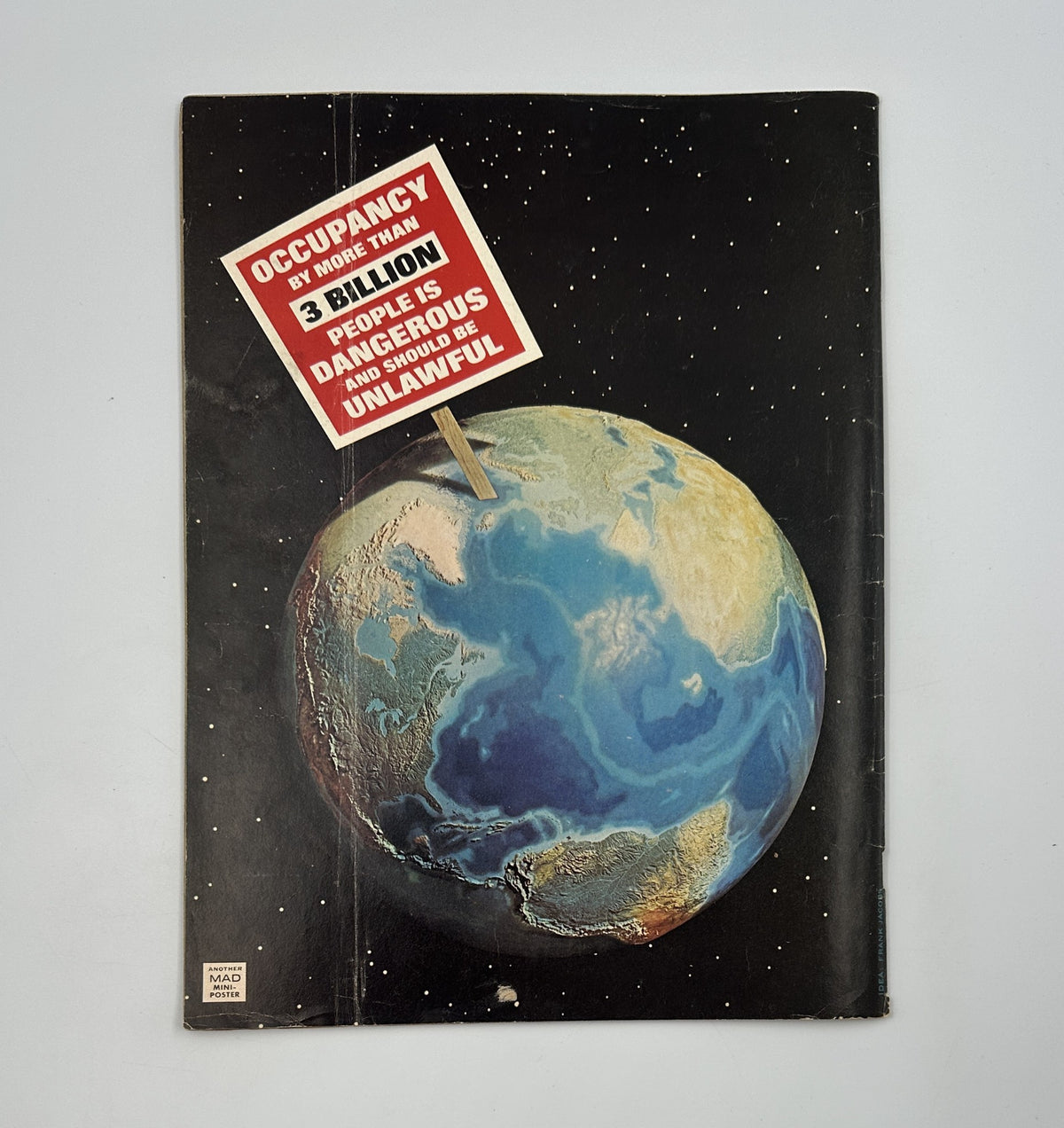 Back cover of MAD Magazine No. 176 from July 1975 depicting a cartoon Earth with a satirical sign illustrating a humorous commentary on occupancy laws, aligning with the magazine's comedic tone.