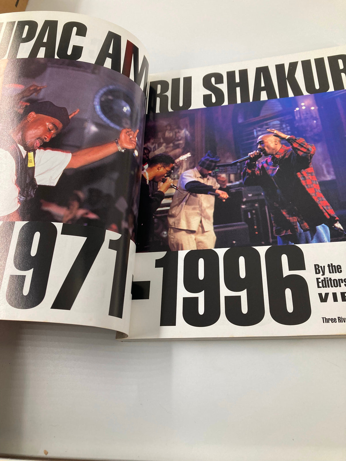 Interior page of The New York Times Best Seller Memoir of Tupac Shakur 1971 - 1996, showcasing a photograph and the text 'TUPAC AMARU SHAKUR 1971-1996'.