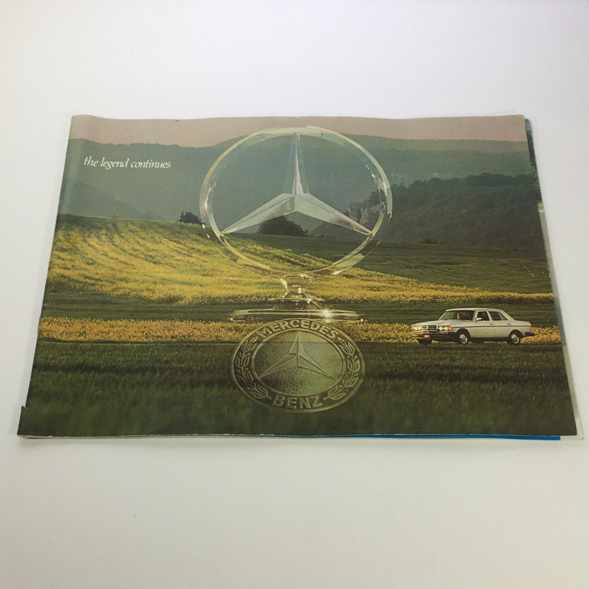 1970s Mercedes-Benz 280SE 450SEL 450SL Dealership Car Auto Brochure Catalog featuring the iconic Mercedes logo and a classic car set against a picturesque landscape.