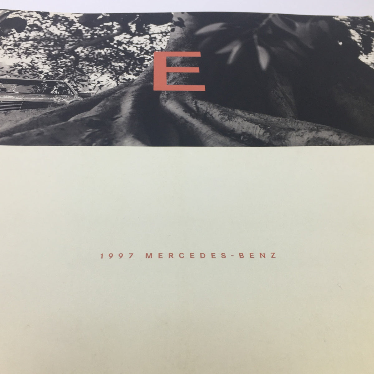 Close-up of the front cover of the 1997 Mercedes-Benz E-Class Dealership Car Auto Brochure Catalog, highlighting the design with the letter 'E' and nature elements.