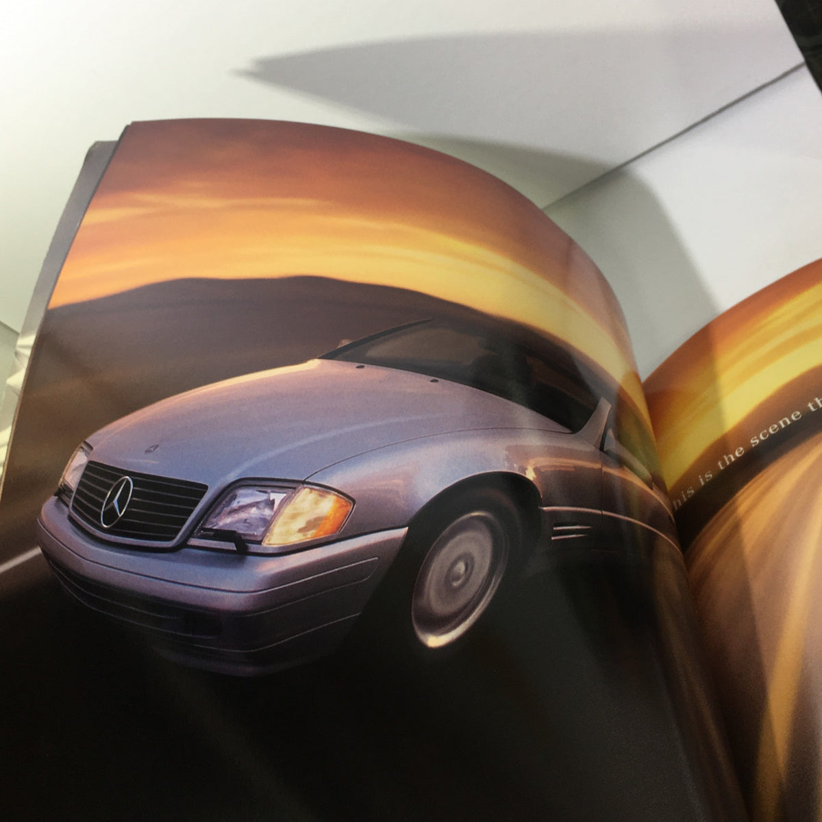 Interior page of the 1997 Mercedes-Benz SL-Class Dealership Car Auto Brochure featuring a stunning image of the SL-Class on a scenic road at sunset.