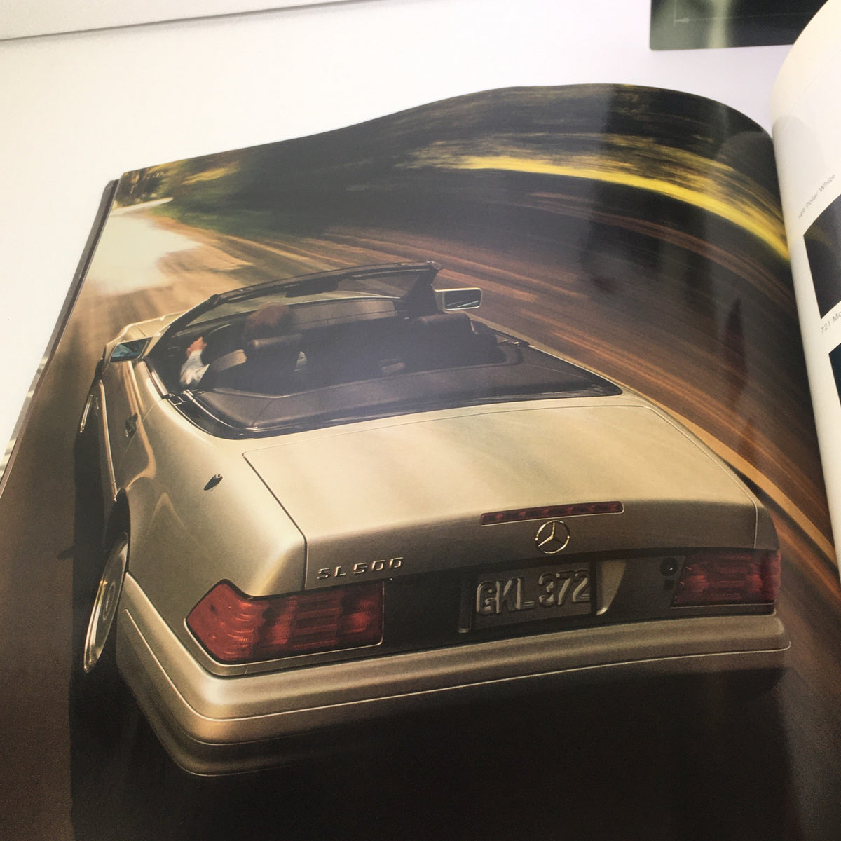 1997 Mercedes-Benz SL-Class Dealership Car Auto Brochure Catalog showcasing the elegant rear view of a silver SL-Class vehicle in motion, illustrating its sleek design and luxury appeal.
