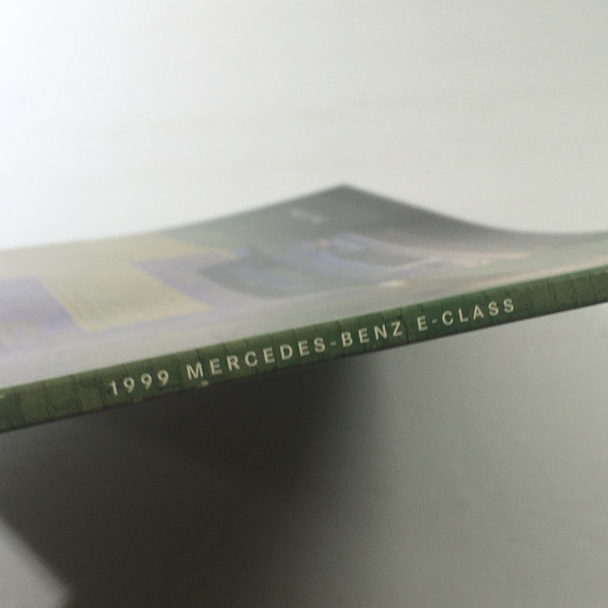 Side view of the 1999 Mercedes-Benz E-Class Dealership Car Auto Brochure Catalog revealing the spine with '1999 MERCEDES-BENZ E-CLASS' printed.