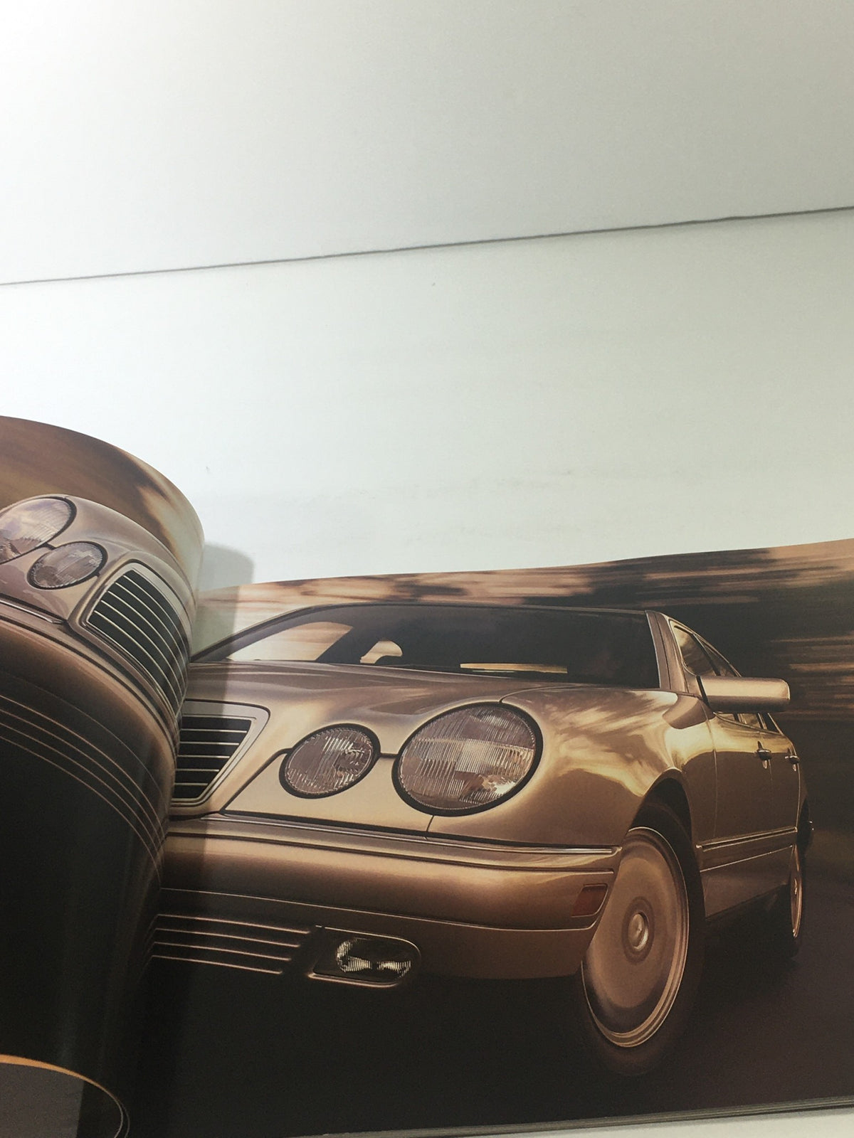 1999 Mercedes-Benz E-Class Dealership Car Auto Brochure Catalog featuring a close-up view of the vehicle's front with a sleek design.