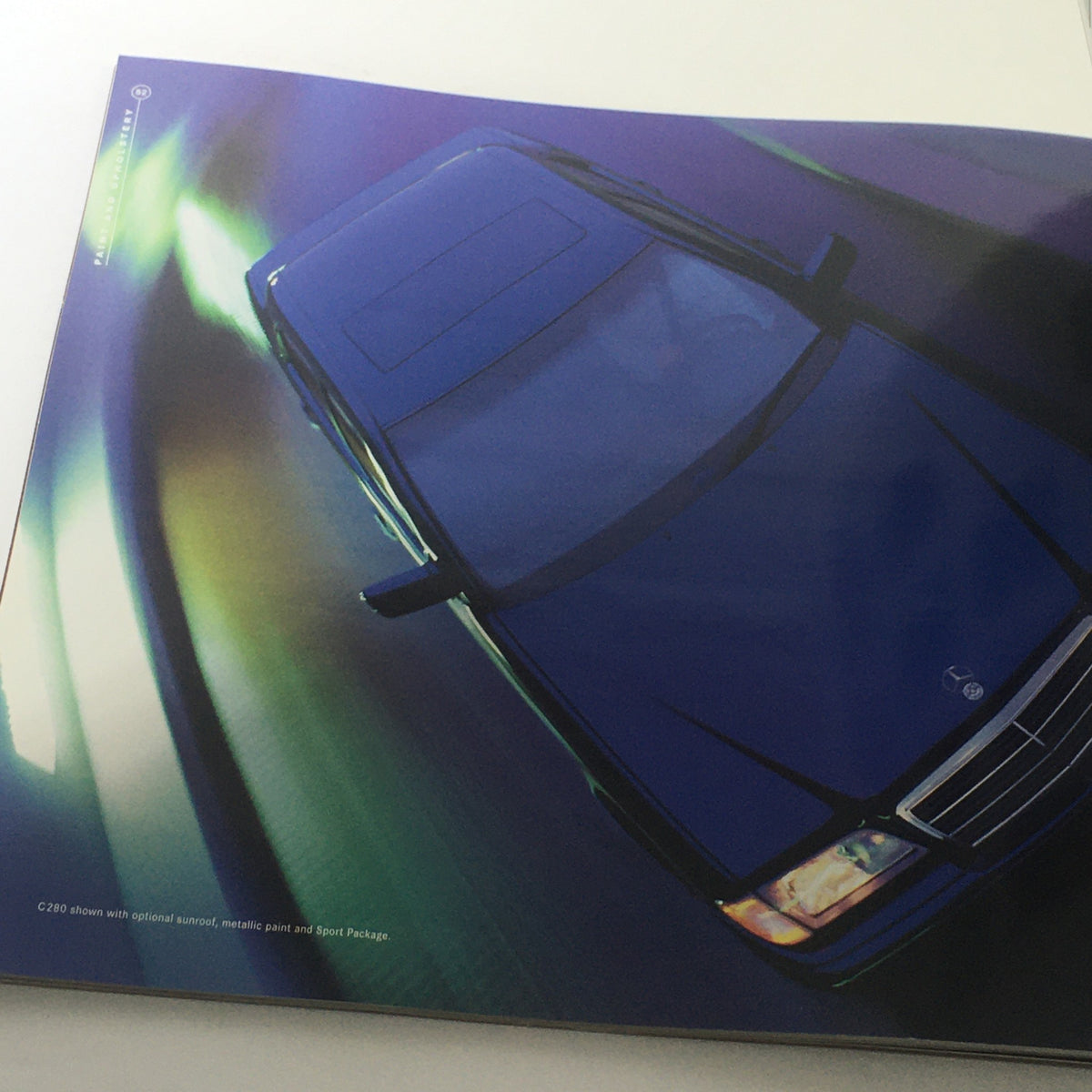 Overhead view of the 1998 Mercedes-Benz C-Class brochure featuring an artistic representation of the car.