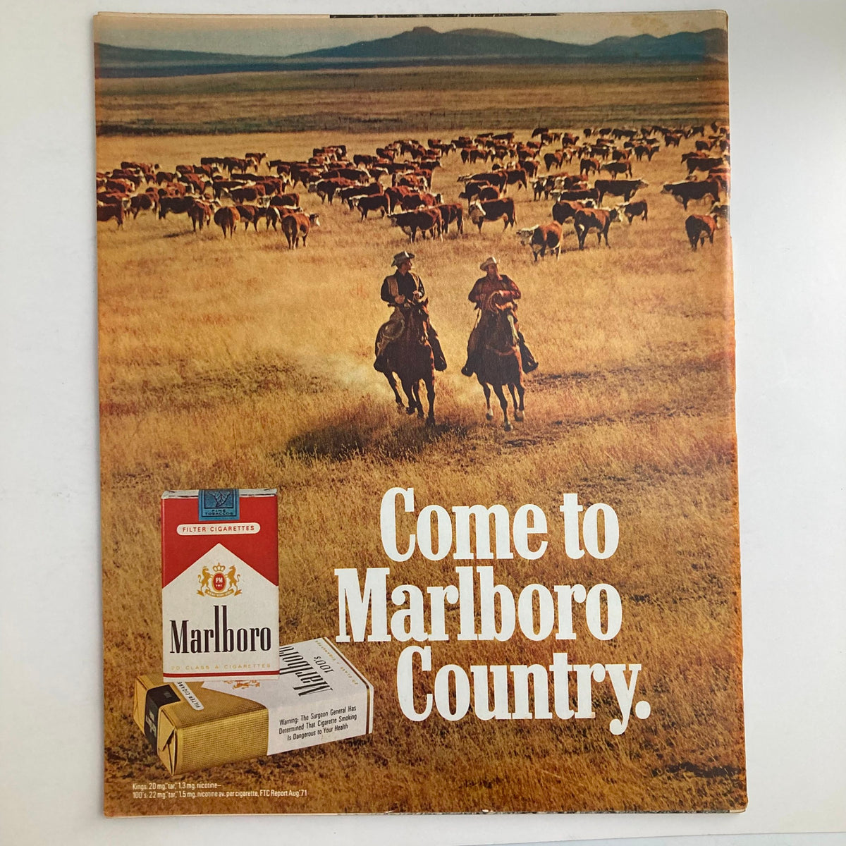 Vintage advertisement featuring cowboys on horseback in a grassy field, promoting Marlboro cigarettes with the tagline 'Come to Marlboro Country.' Includes a Marlboro pack and imagery evoking the classic American West.