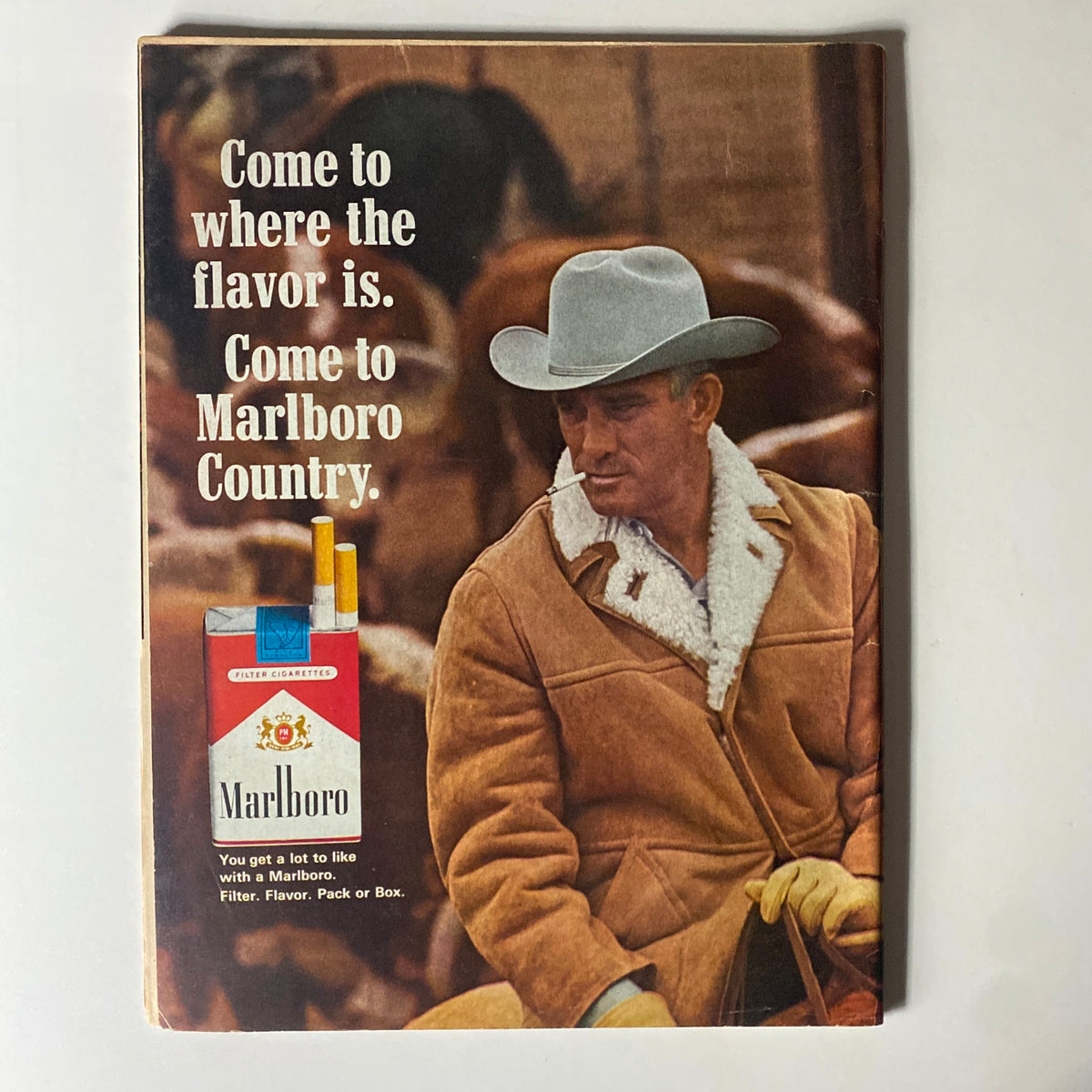 Back cover of a vintage magazine featuring a Marlboro advertisement, promoting the brand with the slogan 'Come to where the flavor is. Come to Marlboro Country.' highlighting Western themes.